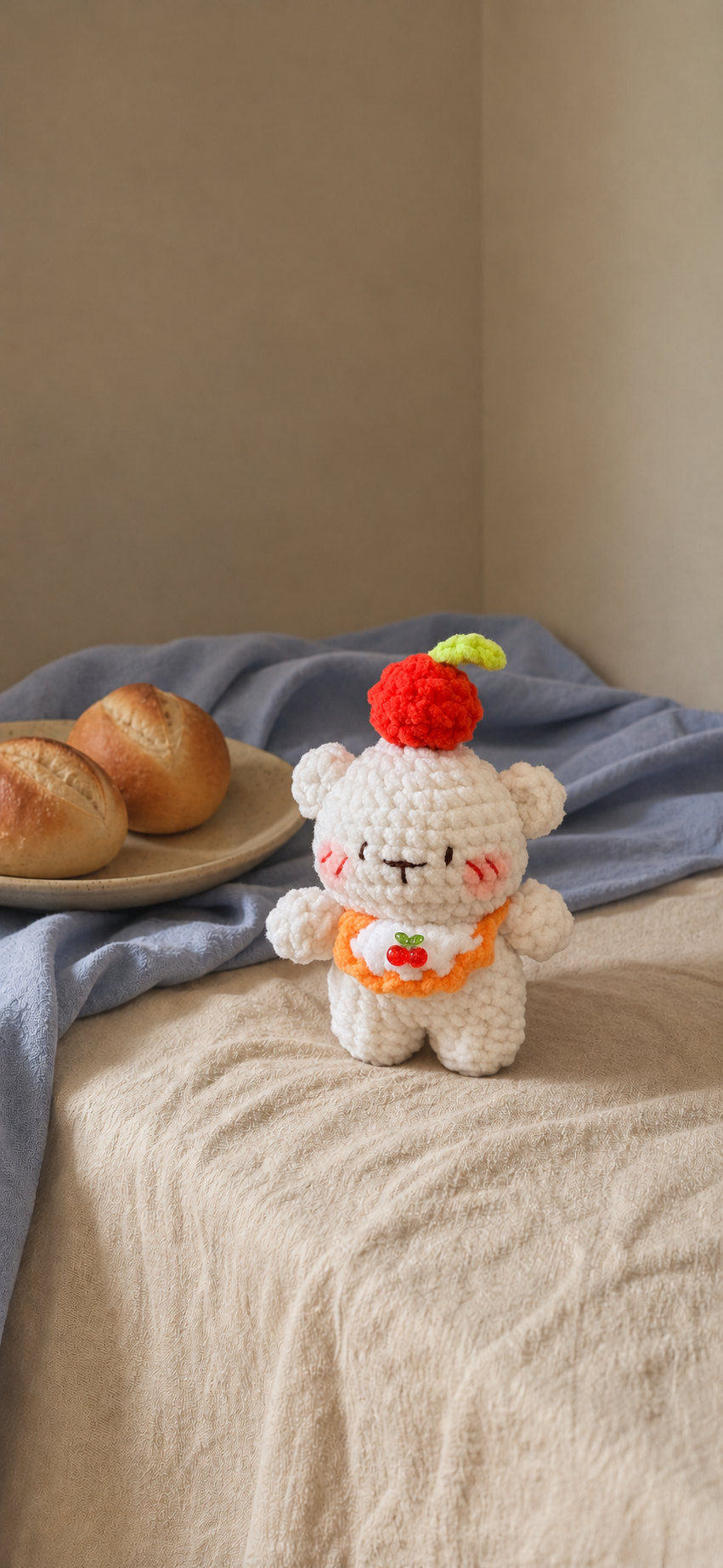 White crochet cherry bear with orange-edged bib