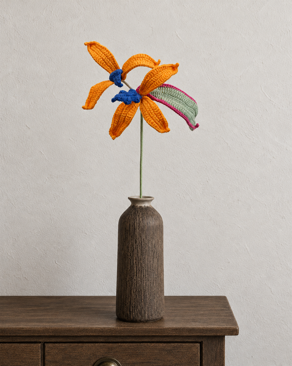 Crochet bird of paradise with orange and blue flowers in a walnut-brown textured vase; vase not included